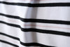 White colored jersey fabric with black and pink stripes made from bamboo and cotton.