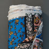 Blue, pink, black, and yellow colored crepe fabric with a flower and paisley print made from rayon.