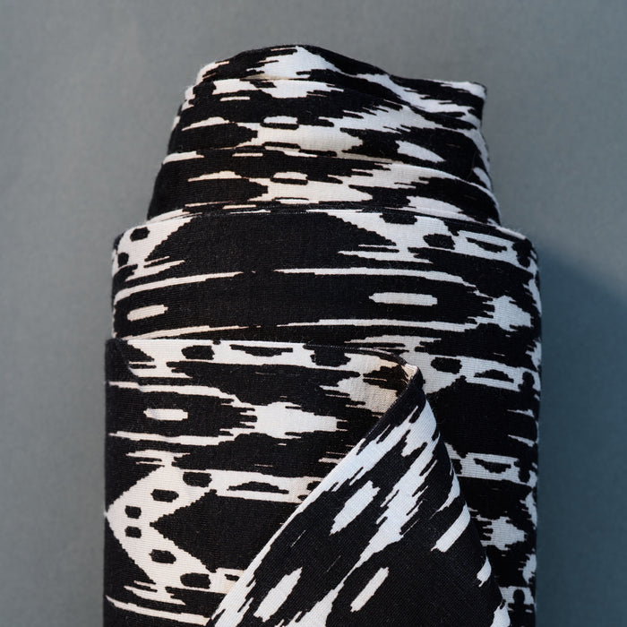 Jersey fabric with a black and white ikat print made from rayon and spandex.