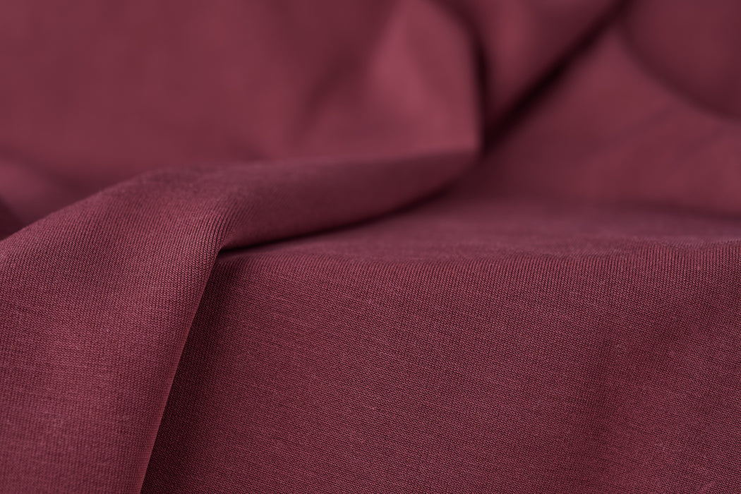 Merlot red colored scuba fabric made from TENCEL™ modal, polyester, and spandex.